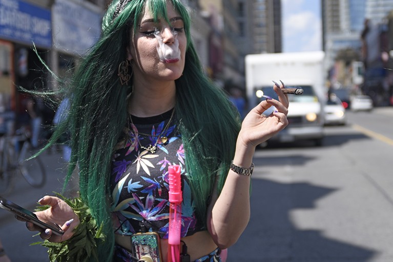 A teenage girl smoking a marijuana blunt during the Toronto Global Marijuana march 2018, Canada.