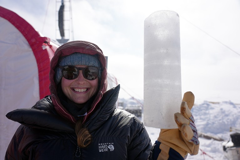 A researcher holds up a segment of the ice core extracted from the mid- to upper-reaches of Prudhoe Dome, Greenland.