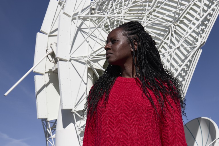 Sthabile Kolwa in front of the MeerKAT (Karoo Array Telescope) radio telescope at Meerkat National Park, Karoo Hoogland, Northern Cape, South Africa.