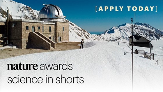 Observatory in snow capped mountain landscape with blue skies