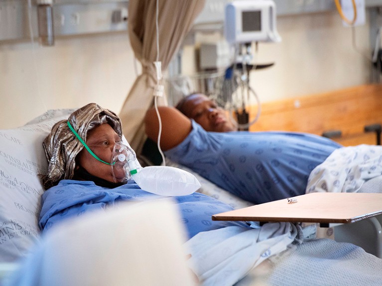 Two patients with COVID-19, one (L) breathing in oxygen, is seen in the COVID-19 ward at Khayelitsha Hospital, about 35km from the centre of Cape Town, on December 29, 2020.