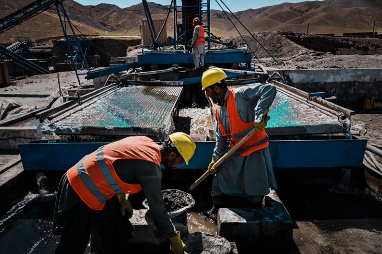 Workers wearing yellow hard hats handle the extraction process for chromium at a mine processing centre