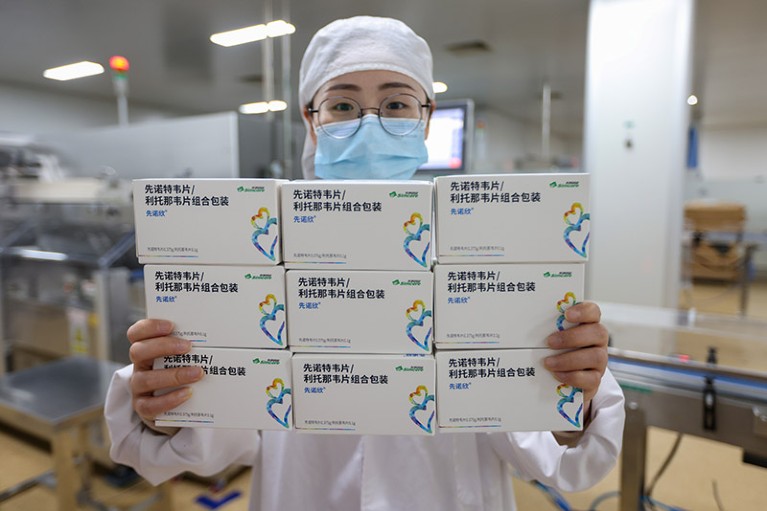 Een medewerker houdt dozen vast op de productielijn van het Simcere Pharmaceutical Group COVID-19-medicijn "XIANNUOXIN" in China.