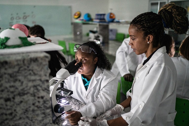 A teacher supporting students during a class in a lab.