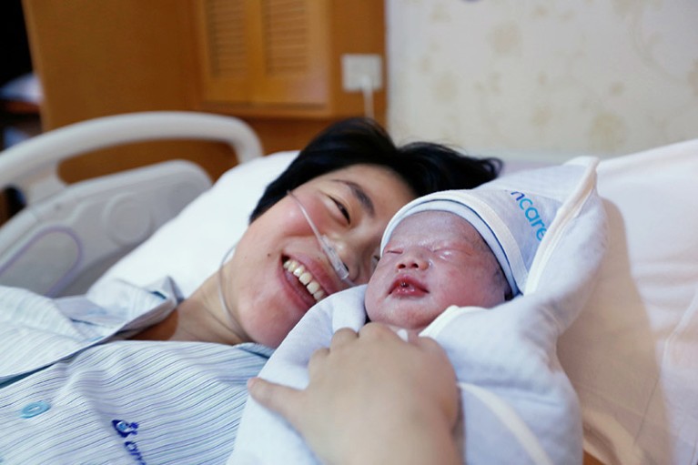 A Chinese mother looks at her newborn baby at a hospital in Beijing.