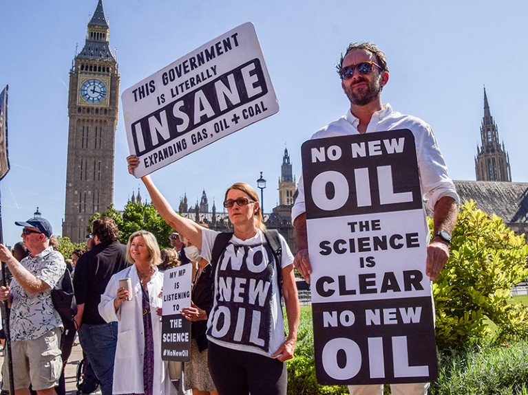 Scientists and climate activists hold anti-oil placards during the demonstration.