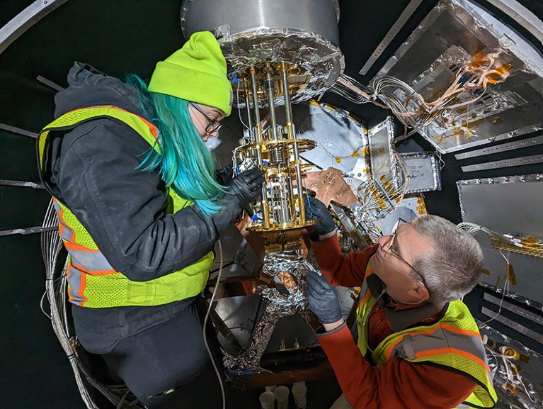Graduate student Anna Kofman and Astrophysicist Simon Dicker from the University of Pennsylvania work on the dilution refrigerator inside the Simons Observatory Large Aperture Telescope Receiver (LATR).