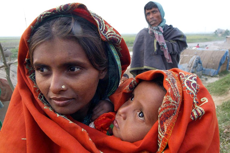Close-up of a Bangladeshi mother holding her warmly wrapped baby