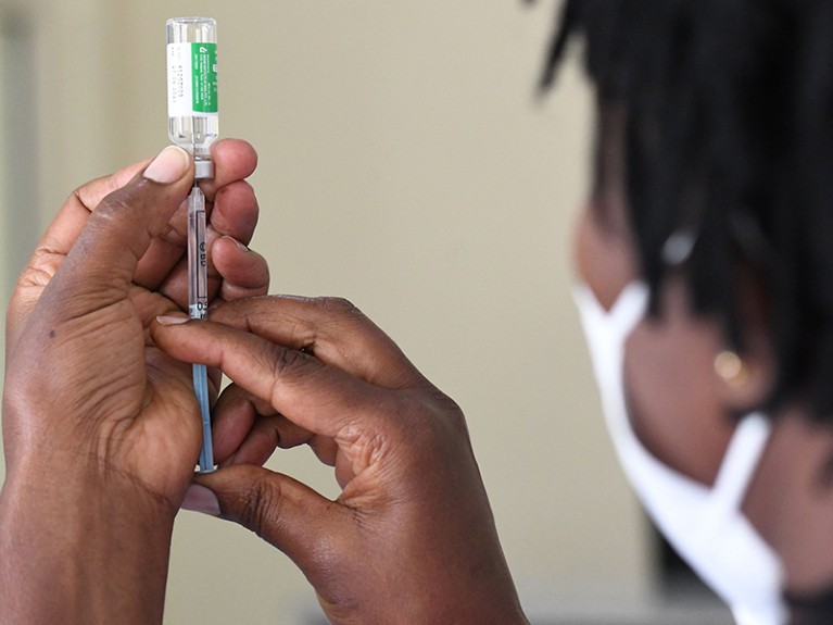 A Kenyan health worker prepares to administer a dose of the Oxford/AstraZeneca vaccine to her colleagues, Nairobi.
