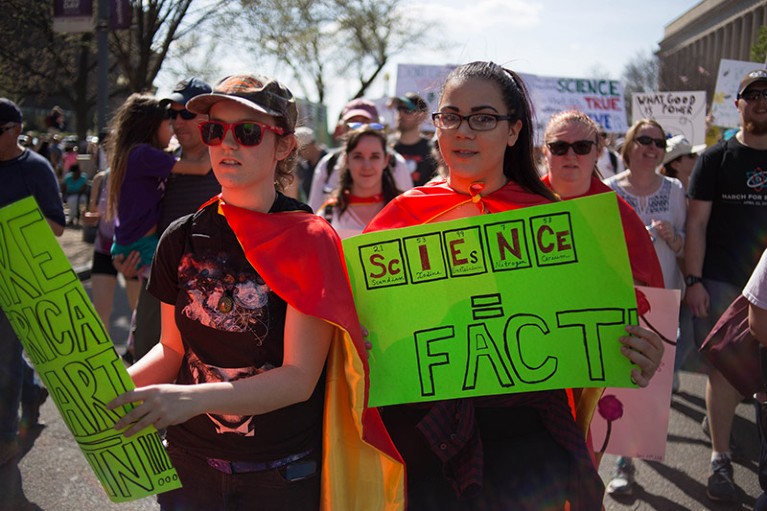 Protestors in Washington DC walk with signs and banners during the March For Science in 2018.
