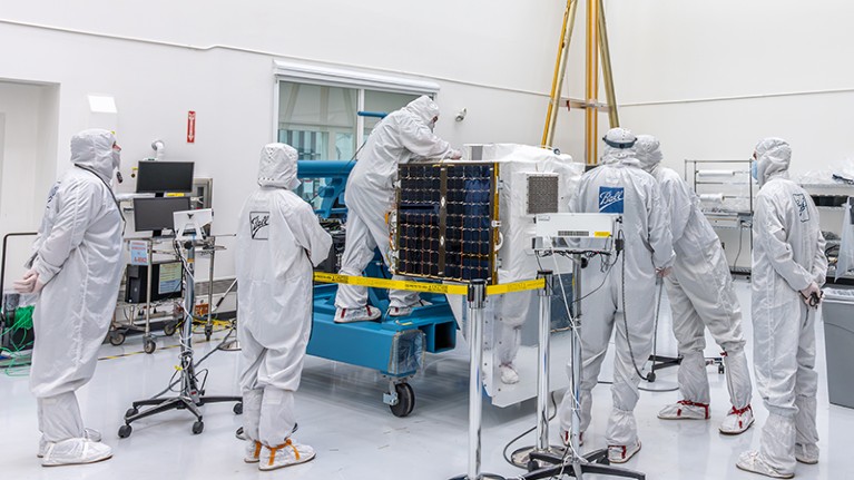 BAE Systems' MethaneSat being worked on in a clean room by multiple technicians in protective clothing.