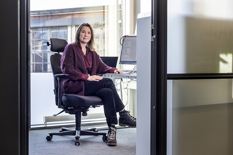 Siri Eldevik Håberg sitting at her desk in front of window.