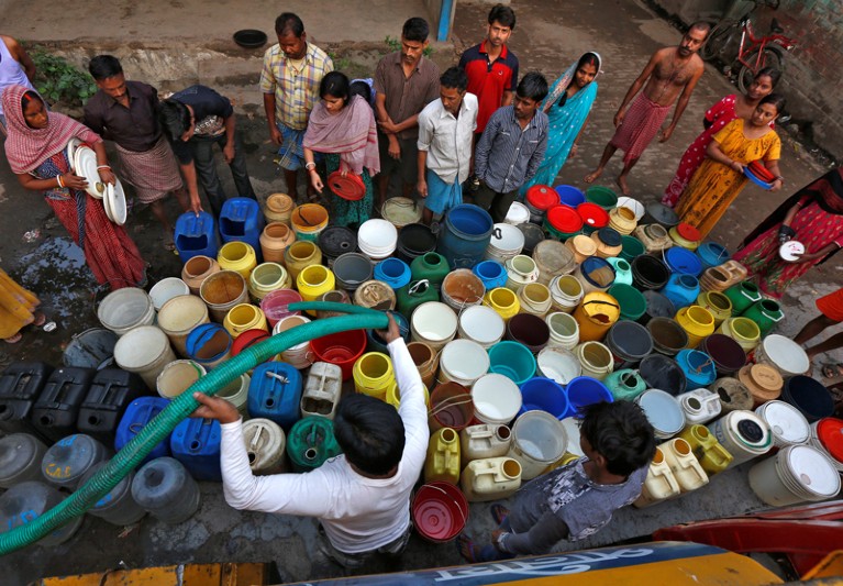 Residents get their containers filled with drinking water from a municipal tanker in India