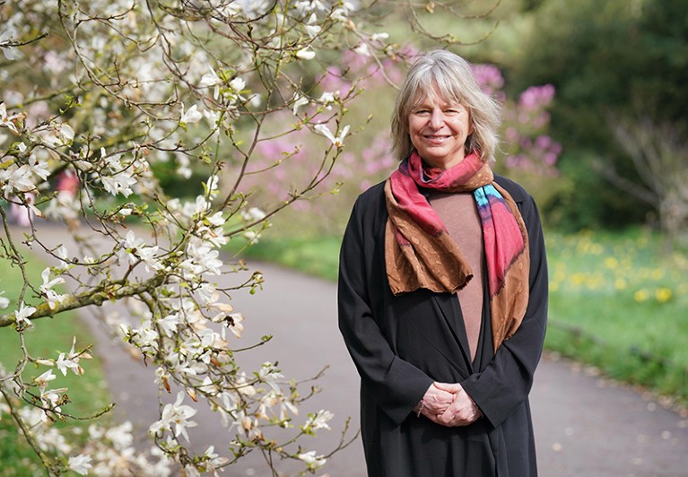 Portrait of Suzanne Simard next to a flowering tree.