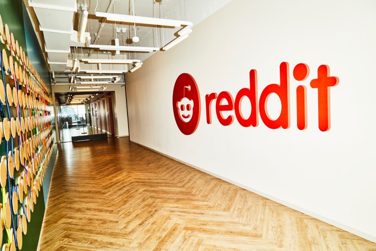 A hallway at Reddit's office in New York, with a large Reddit logo on the white wall