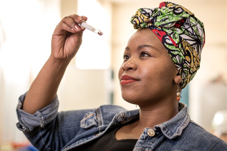 Portrait of Palesa Mothapo looking at ants in an Eppendorf tube