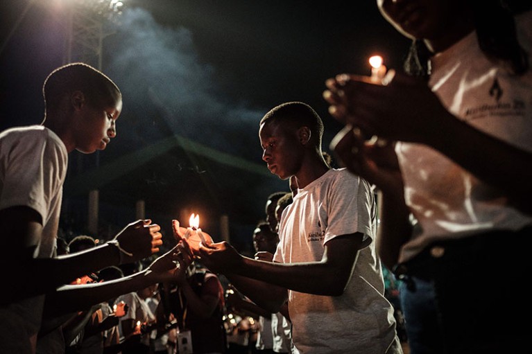 Young people light candles at a commemoration ceremony for the genocide in Rwanda