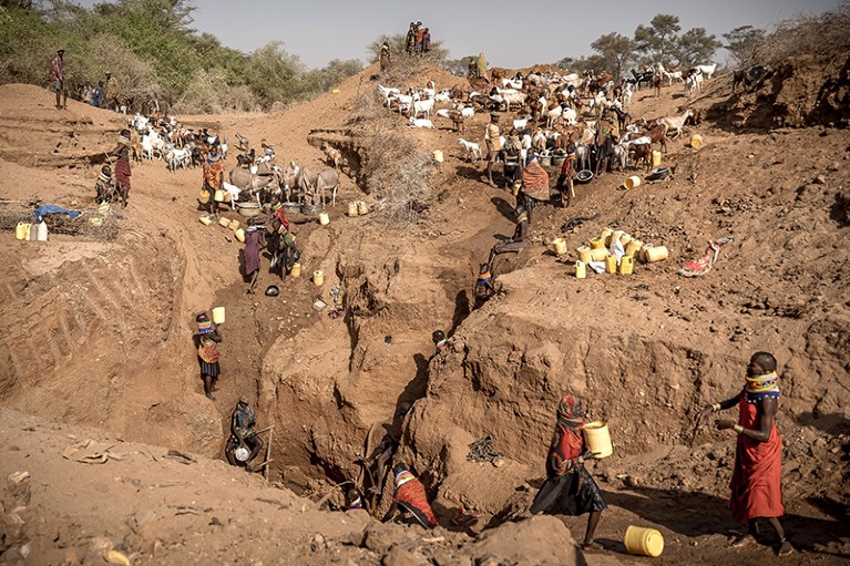 Turkana people source water from a low-level outdoor well to survive drought in Northern Kenya, 2023.