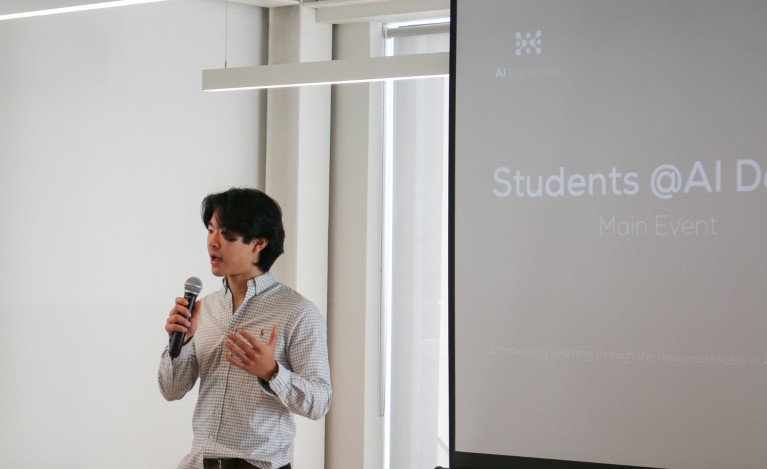 Yan Jun (Leo) Wu speaks into a microphone while opening the Students@AI Conference