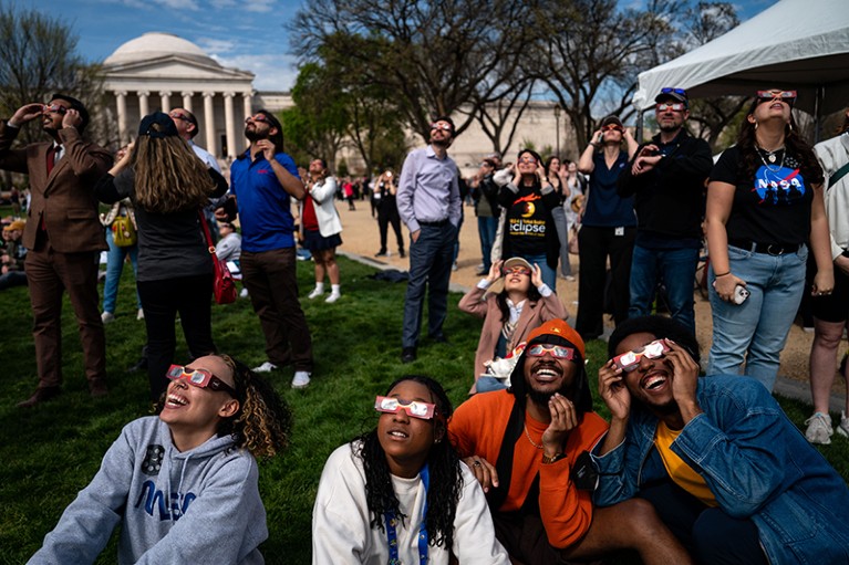 People gather on the National Mall to view the partial solar eclipse on April 8, 2024 in Washington, DC, U.S.