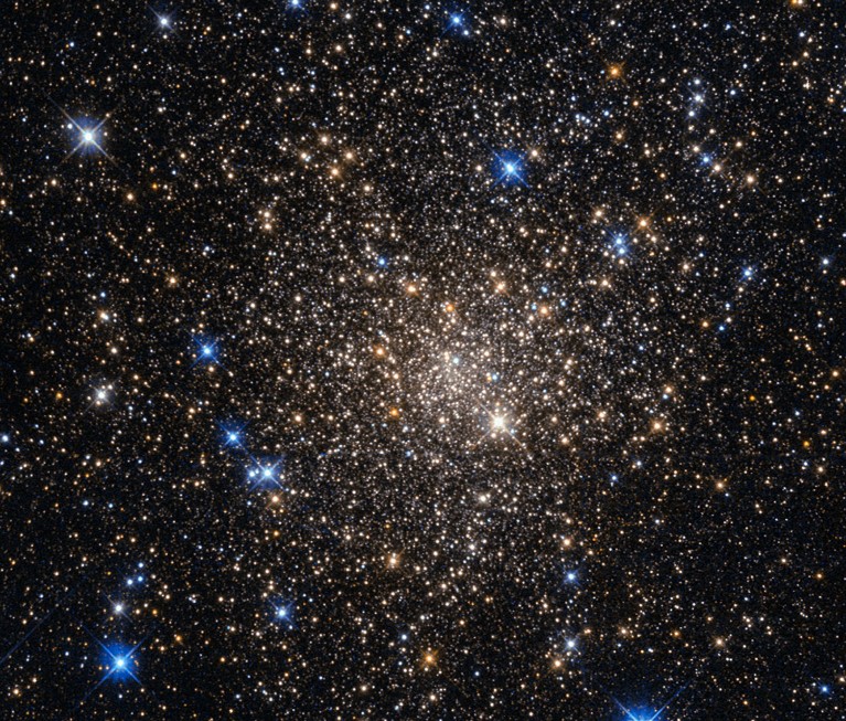 A cluster of white, yellow and blue stars against a black background.