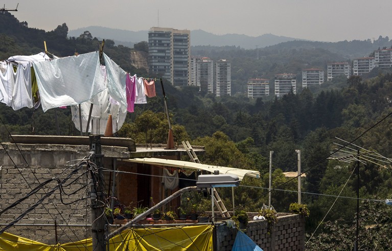 General view of houses constructed over ravines in a poor zone behind rich housing developments in Mexico City , on July 24, 2012.