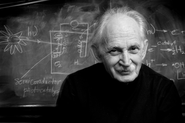 Black and white portrait of Professor Allen J. Bard in front of a blackboard