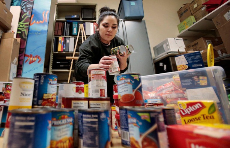 Low-angle view of a person sorting through food donations for the Open Seat, an on-campus food pantry