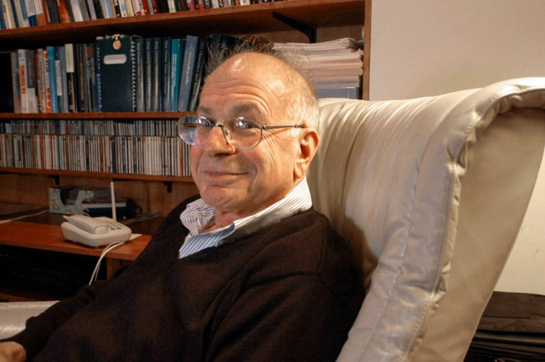 Portrait of Daniel Kahneman in an armchair in his home