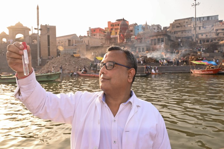Anurag Chaurasia holds up a tube of water from the holy river Ganga
