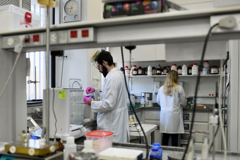 Duas pessoas vestindo jalecos trabalhando em um laboratório da Universidade Federal do Rio de Janeiro
