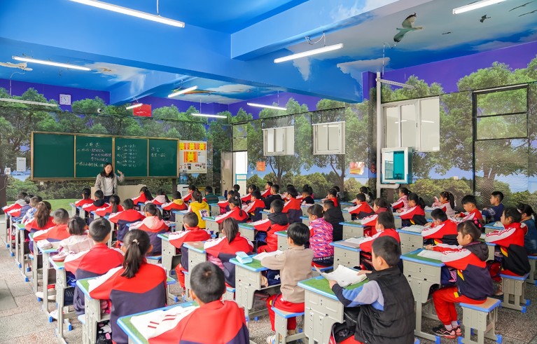 Grade-3 students sit in an outdoor scene classroom in China, Lijiang Shiyan School, Yunnan province in China.