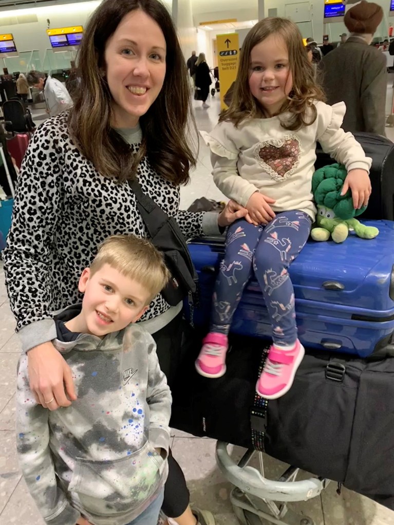 Laura Carter with her two children during pre-flight at an airport.