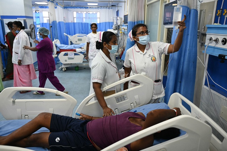 Two nurses care for a patient with heat stroke in a hospital ward in Chennai, India.