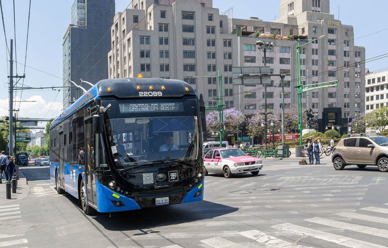 A blue electric bus pictured at a busy road junction in Mexico City.
