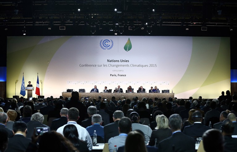 A number of delegates on stage in front of a large audience during the opening ceremony of the COP21 climate change conference that took place in Paris in 2015.