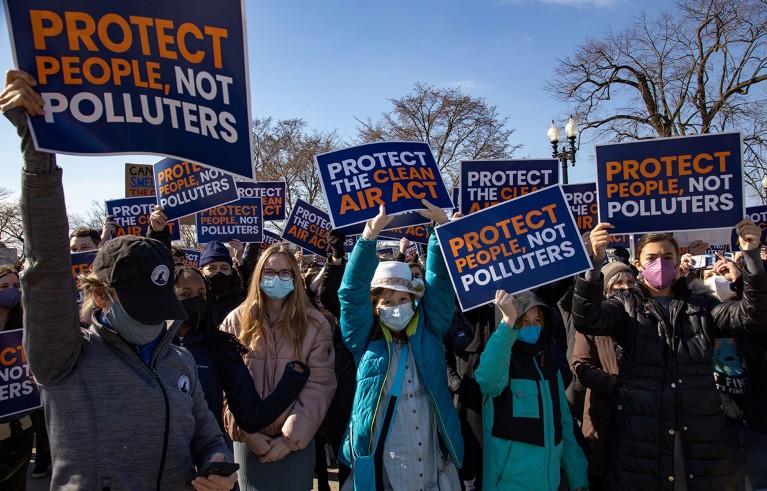 Activistas del cambio climático con máscaras y carteles se reúnen frente a la Corte Suprema en Washington.