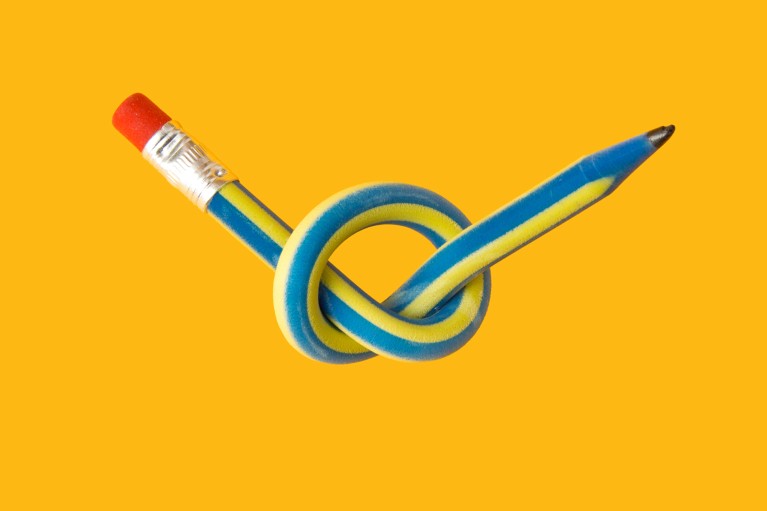 A bendy blue and yellow pencil tied in a knot on a yellow background
