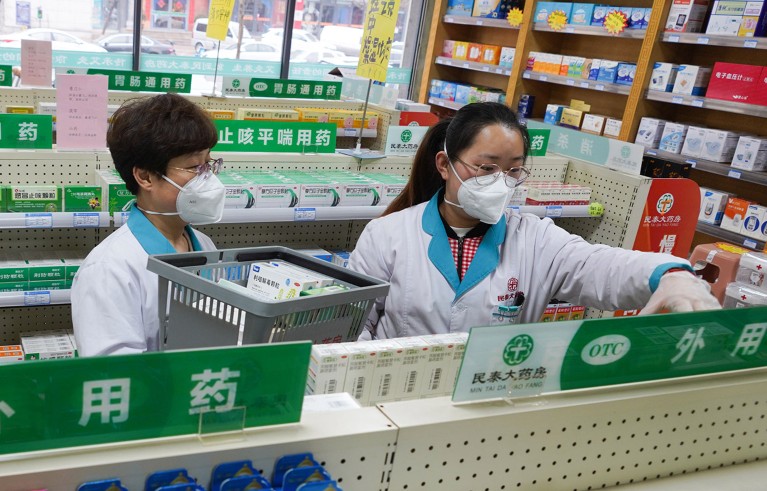 A pair of staff members organises medicine on shelves at a medical insurance convenience pharmacy in Zouping, East China's Shandong province.