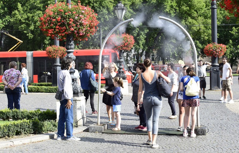 Una neblina de agua ayuda a la gente del centro de Bratislava a refrescarse en un caluroso día de verano.