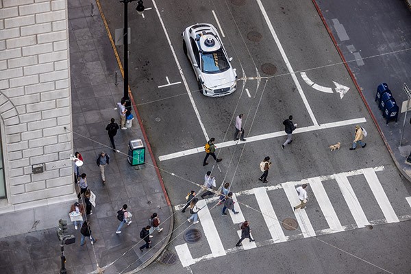 Una vista de ángulo alto de un automóvil autónomo se detuvo para permitir que los peatones cruzaran la calle en San Francisco.