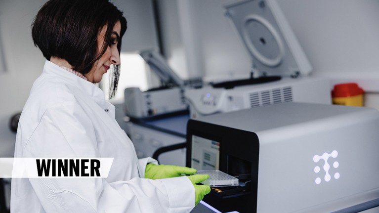 A scientist inserts samples into a machine in a laboratory