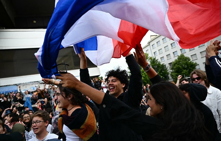 People celebrate with the French national flag during a rally in Nantes, western France.