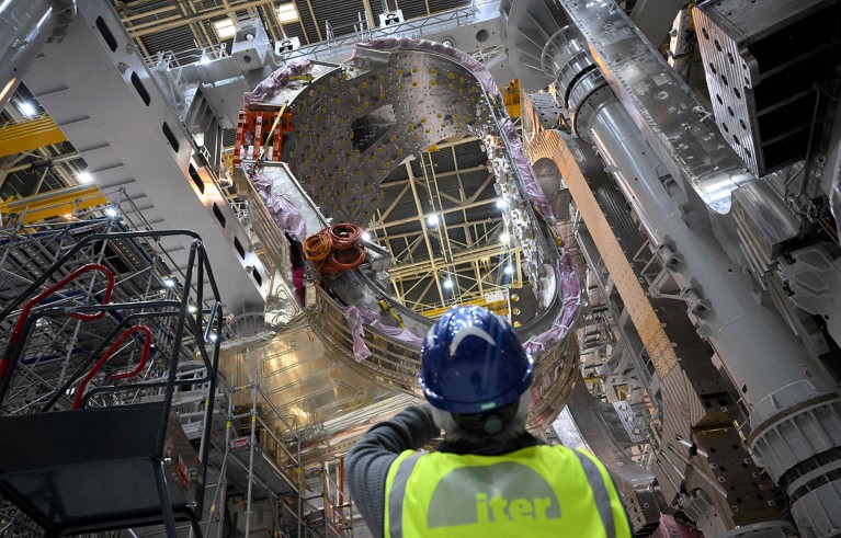 A man wearing a hardhat looks up at a module being assembled at the international nuclear fusion project ITER in Saint-Paul-les-Durance, southern France.