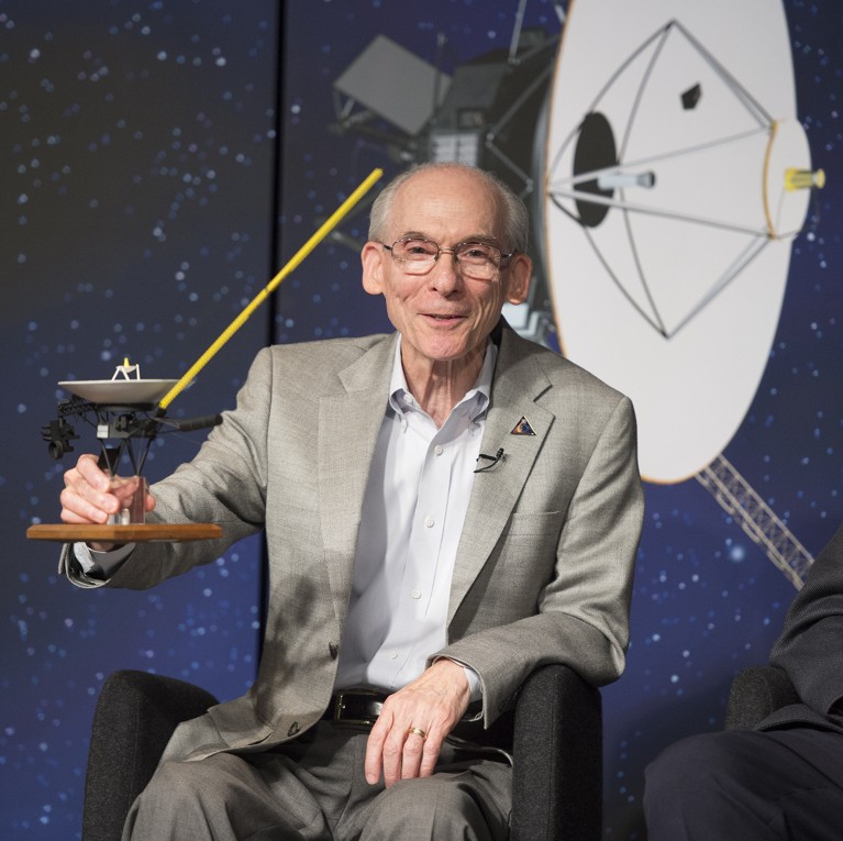 Edward Stone, Voyager project scientist, holds up a model of NASA's Voyager spacecraft at a press conference in 2013.