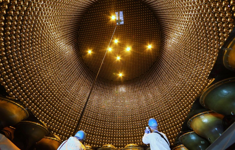 Two people in protective clothing pictured inside the tank of Super-Kamiokande.