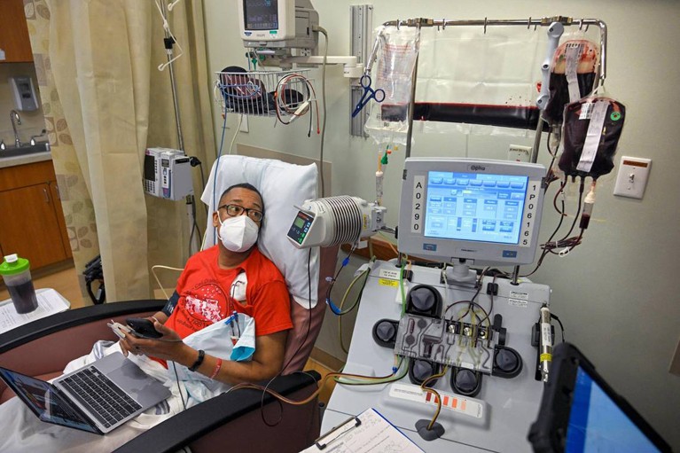 A patient with sickle cell disease receives blood transfusions in a hospital room surrounded by medical equipment.