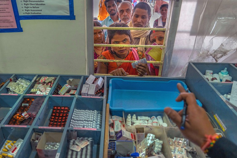 A child who has sickle cell disease listens to instructions from a pharmacist before receiving free medicine in India.