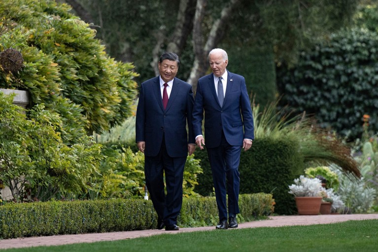 Joe Biden and Xi Jinping walk together in a garden during a summit of world leaders