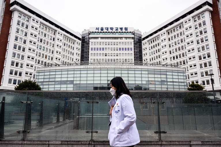 A medical worker walks past the Seoul National University Hospital in Seoul, South Korea.